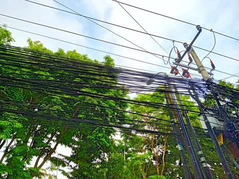 Electrical poles and cables on the side of the road Stock Photos