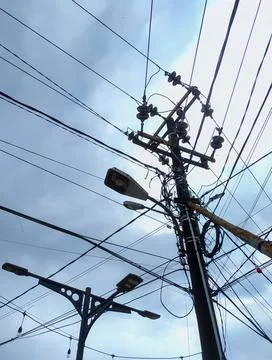 Electrical poles with irregular cable installations Stock Photos