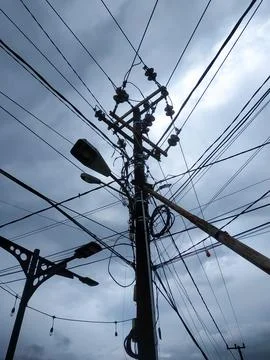 Electrical poles with irregular cable installations Stock Photos