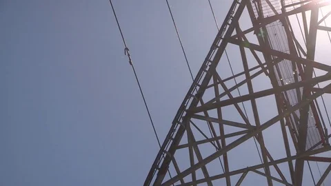 Electrical power grid transmission tower and lines with bright sun shining Stock Footage 75660117
