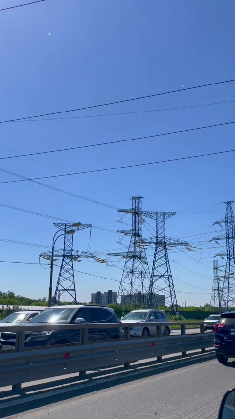 Electrical power line pylon above a busy highway. Transmission tower with Stock Footage 339432145