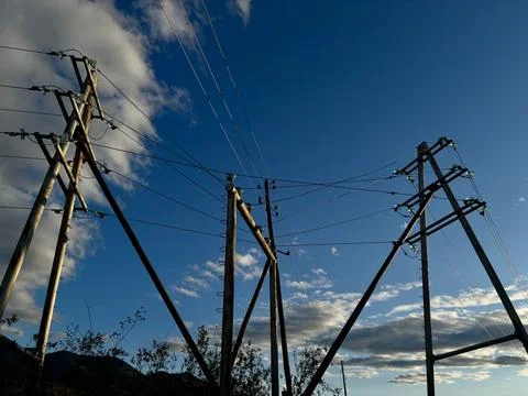 Electrical power lines and utility poles against blue sky Stock Photos