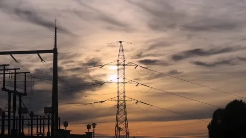 Electrical power lines pylon silhouetted at sunset Stock Footage 326790241
