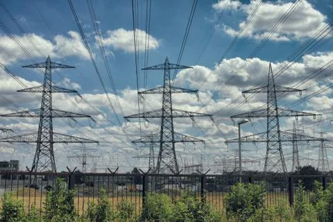 Electrical power lines as sun sets in background blue nature Foto stock