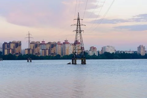 Electrical power lines through a river at sunset Stock Photos