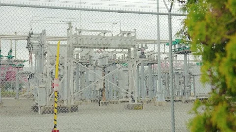 Electrical power substation infrastructure behind chain link fence Stock Footage 333220702