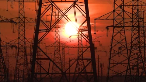 Electrical power transmission grid with red sunset and power lines Stockbeeldmateriaal 149384875