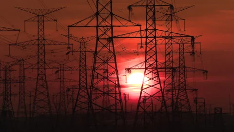 Electrical power transmission grid towers and lines with red sky and sun Video stock 149416637