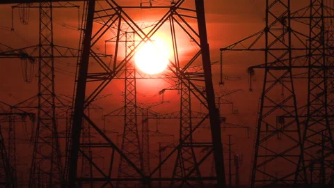 Electrical power transmission grid towers and lines with red sky and sun Video stock 149422455