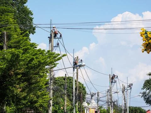 An electrical power utility worker fixes the power line 스톡 사진