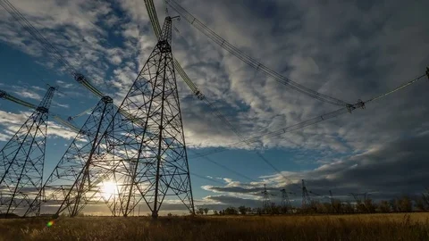 Electrical pylons against timelapse clouds at the sunset Stock Footage 75490024