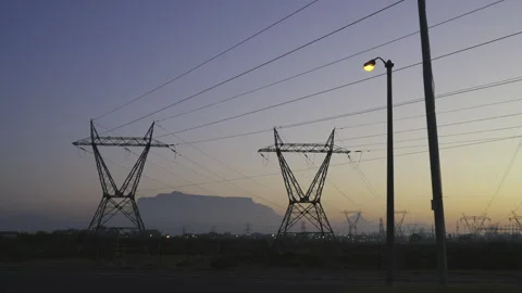 Electrical pylons against twilight sky Table Mountain and Cape Town backdrop Stock Footage 345547640
