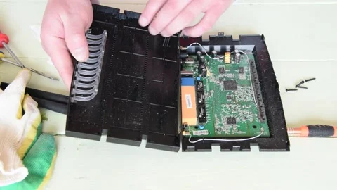 An electrical repair technician disassembles an old Wi-Fi modem. Stock Footage 151136540