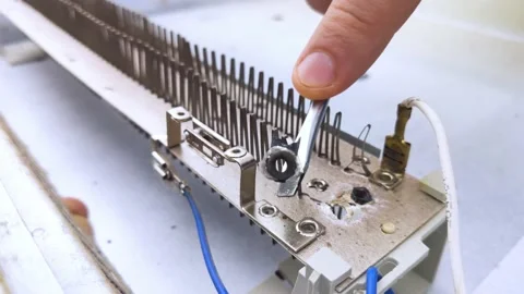 An electrical repairman repairs a convector. A close-up of an open heater and it Stock Footage 146840286