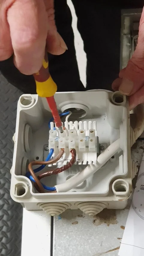 Electrical service engineer inspecting wiring inside a junction box and test Stock Footage 334750766