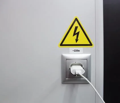 Electrical socket and a plug on the wall. Stock Photos