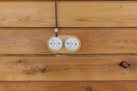 Electrical socket and switch in retro style on a wooden wall. Design of Stock Photos