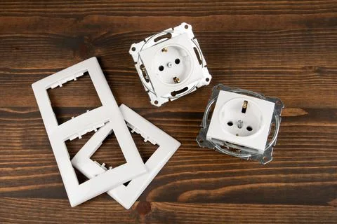 Electrical socket with decorative plastic parts on a wooden background Stock Photos