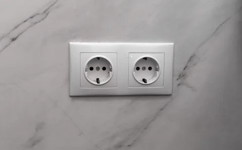 Electrical socket installed in marble wall surface, socket with two outlets.. Stock Photos