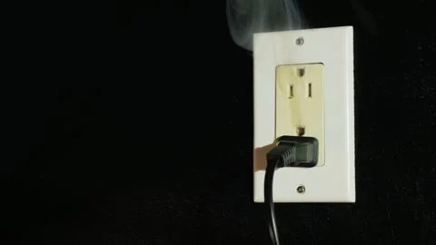 Electrical socket with a plug sparks and emits smoke indicating danger of f.. Stock Footage 334999719