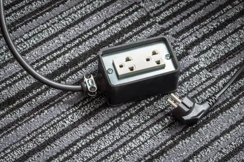 Electrical socket with power plug cable on carpet floor for safety concept Stock Photos
