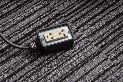 Electrical socket with power plug cable on carpet floor for safety concept Stock Photos