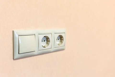 Electrical sockets on light brown painted wall Stock Photos