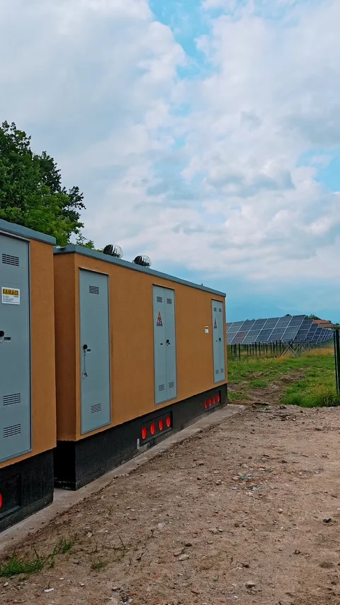 Electrical substation building with solar panels in background Stock Footage 343787608
