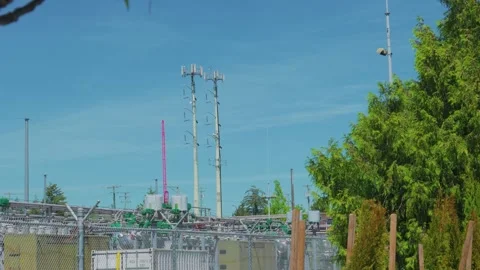 Electrical substation with cellular towers under clear blue sky 库存影片 340183869