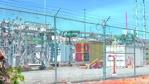 Electrical substation facility behind barbed wire chain link fence Stock Footage 338177891