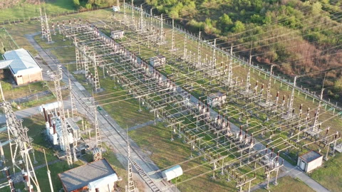 Electrical substation: transformers and grid of pylons, lines and wires Stock Footage 152054966