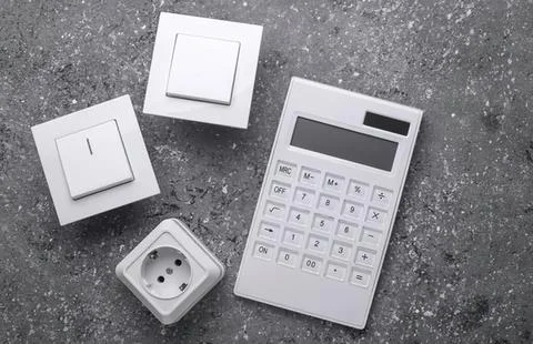 Electrical switch and power outlet with calculator on textured surface Stock Photos