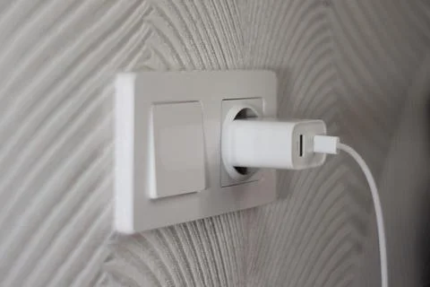 Electrical switch and socket in which the phone charger is inserted Stock Photos