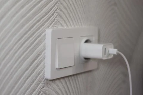Electrical switch and socket in which the phone charger is inserted Stock Photos