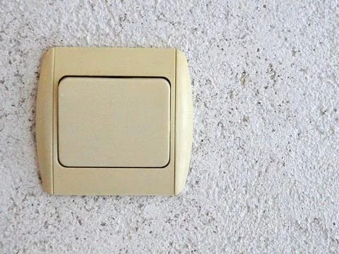 Electrical switch on gray plastered wall close up Stock Photos