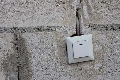 An Electrical Switch Installed on a Concrete Wall to Enhance Functionality and Stock Photos