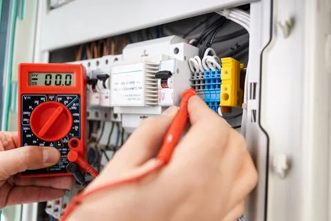 Electrical Technician Measuring Voltage with Multimeter Stock Photos