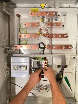 Electrical technician operator works on an electrical panel. Stock Photos