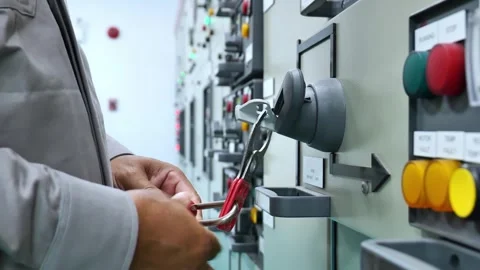Electrical technician performing Lockout Tagout on a power distribution panel af Video stock 343904518
