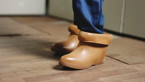 Electrical technician is putting on special protective shoes in power station Stock Footage 194614120