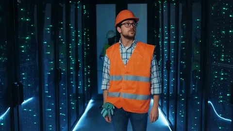 Electrical technician standing in middle of server room, inspecting and Stock Footage 120747428