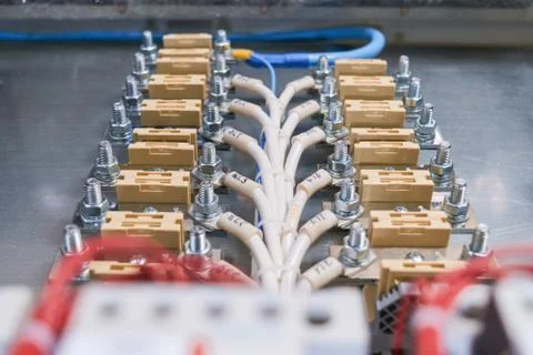 Electrical through-bolt terminals are installed on the mounting panel. Stock Photos