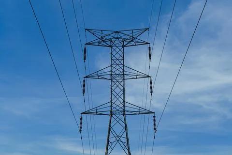 Electrical tower against a blue cloudy sky Stock Photos