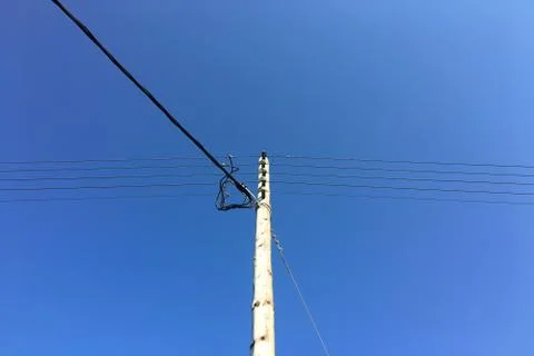 Electrical tower with blue sky background. Old simple rural weathered wooden  Fotos Stock