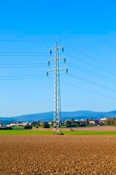Electrical tower in field under blue sky Stock Photos