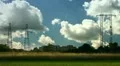 Electrical towers on cloudy sky, near some houses HD Footage