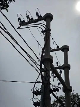 Electrical transformer installation and utility pole against blue sky Stock Photos