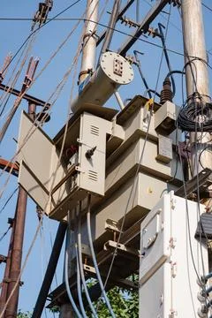 Electrical transformer mounted on utility pole with wires Stock Photos