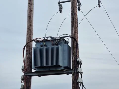 Electrical Transformer on Platform Between Wooden Utility Poles Stock Photos