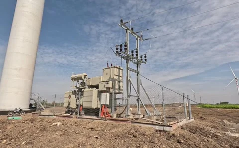 Electrical Transformer Station Positioned Next to Massive Wind Turbine Tower Stock Footage 341709327